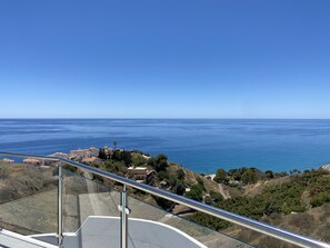 A coastal view from a high vantage point with a clear sky, overlooking a body of water and a landscape with buildings and vegetation. - Apartment in Nerja With Sea Views & Pool (Nerja)