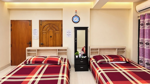 A bedroom with two beds, a wooden wardrobe, a mirror, and a clock on the wall. - AST Guest House (Dhaka)