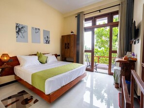 A hotel room with a large bed, a wooden wardrobe, a balcony with a view, and artwork on the wall. - Mashmellow Resort & Spa (Galle)
