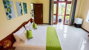 A hotel room with a bed, a wardrobe, a television, and a view of the outdoors. - Mashmellow Resort & Spa (Galle)