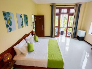 A hotel room with a bed, a wardrobe, a television, and a view of the outdoors. - Mashmellow Resort & Spa (Galle)