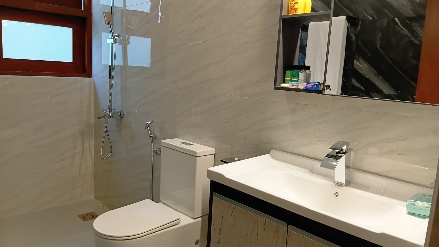 Une salle de bain avec des toilettes, une douche et un lavabo.