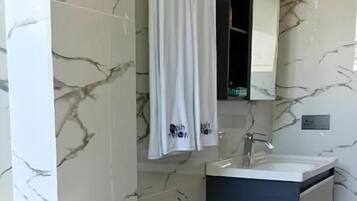A bathroom with a toilet, sink, and mirror.