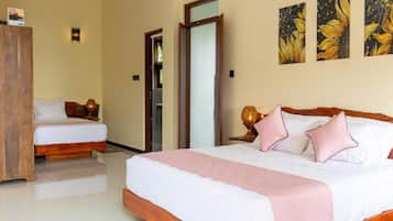A hotel room with a large bed, a smaller bed, a wardrobe, and a door leading to another room.