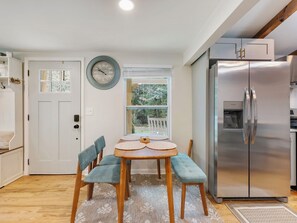 A compact kitchen with a dining area, a refrigerator, and a window with a view of greenery. - Charm and Cozy! (Toccoa)