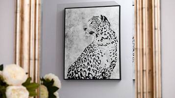 A framed artwork of a leopard on a wall.