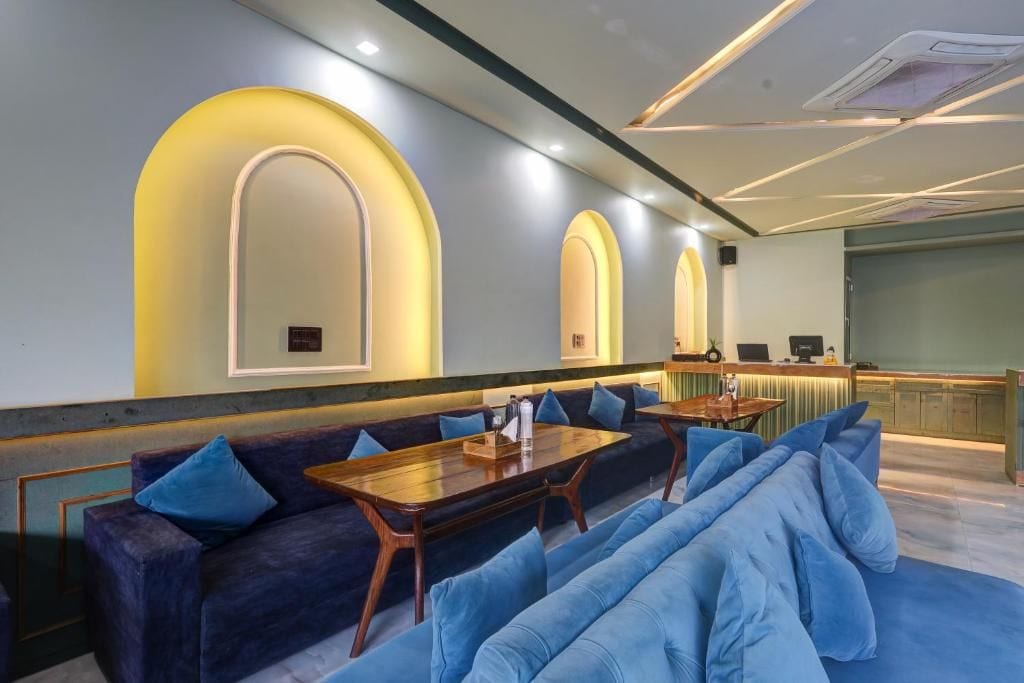 Un interior moderno con una zona de estar que incluye sofás y una mesa de madera, una barra con mostrador y una cocina al fondo.