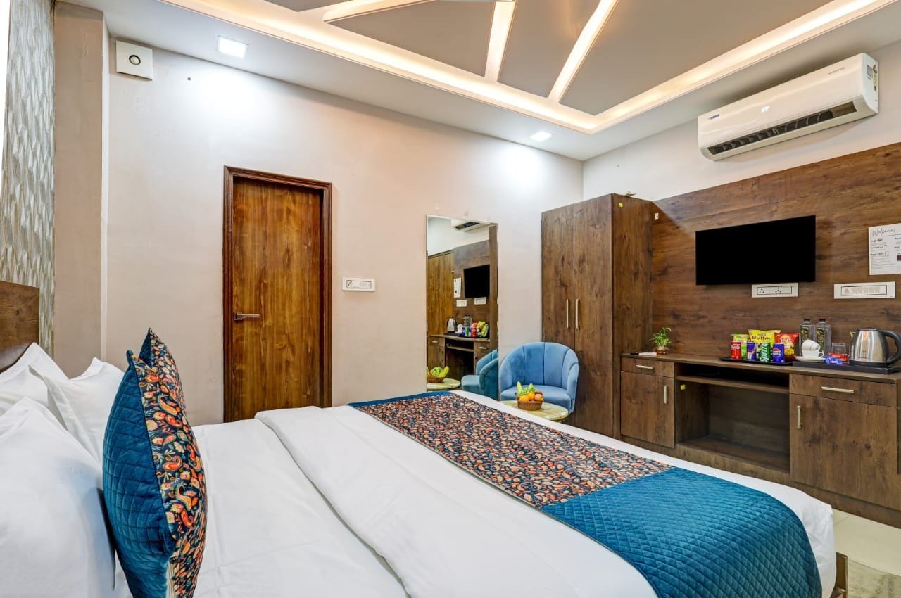 Une chambre d’hôtel équipée d’un lit, d’un bureau, d’une chaise, d’une armoire, d’un climatiseur et d’un téléviseur.