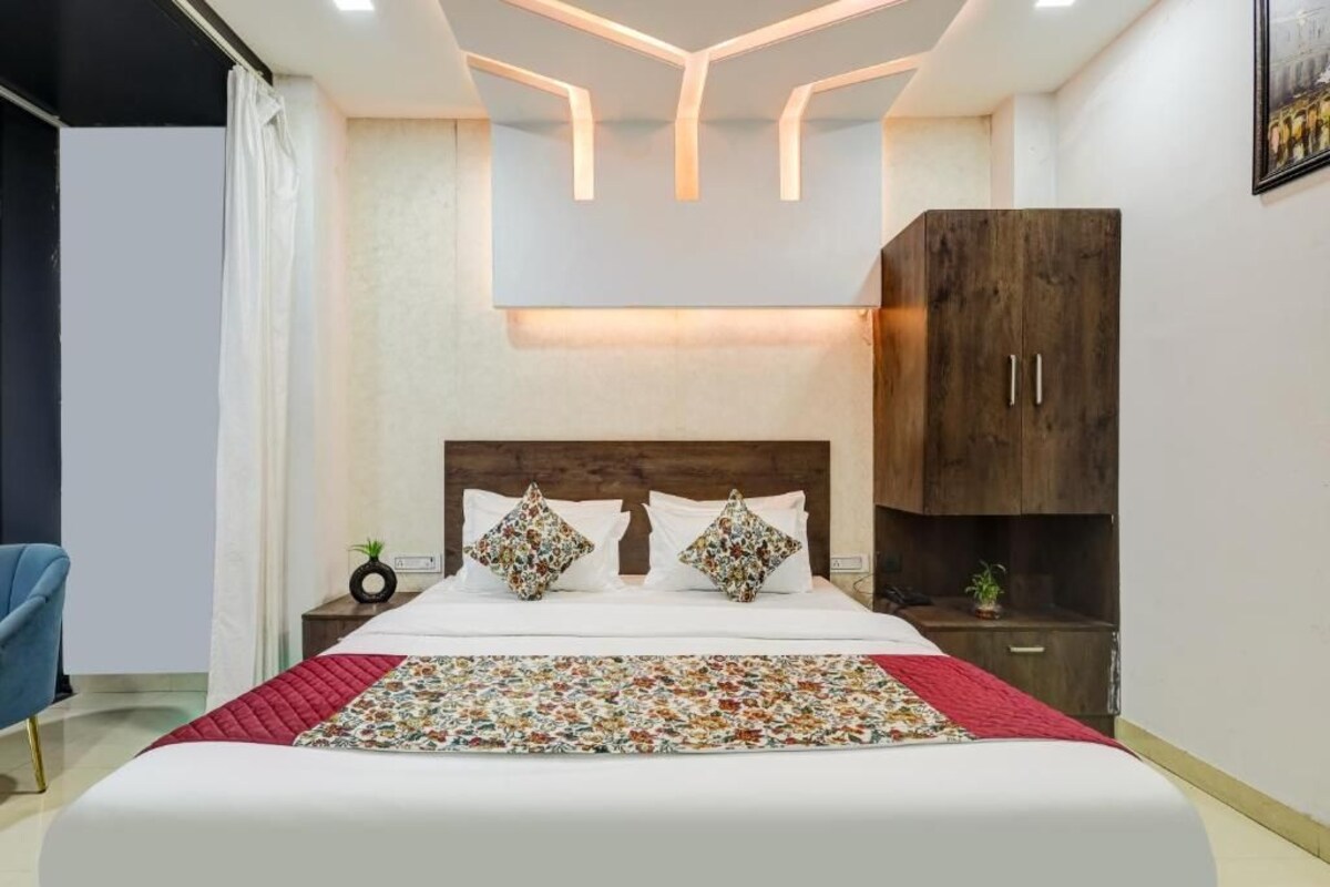 A modern bedroom with a bed, nightstands, a wardrobe, and a unique ceiling design.