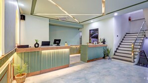 A reception area with a counter, a computer, and a staircase. - Hotel Priyaj  (Jaipur)