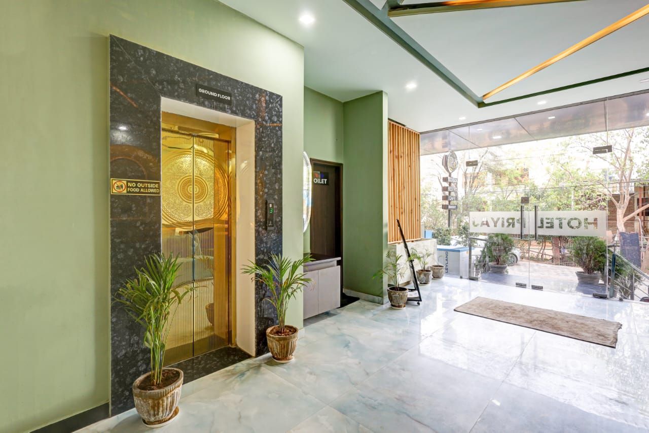 Un vestíbulo de hotel con piso de mármol, una recepción y un cartel que indica la planta baja.