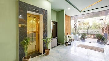 Un vestíbulo de hotel con piso de mármol, una recepción y un cartel que indica la planta baja.