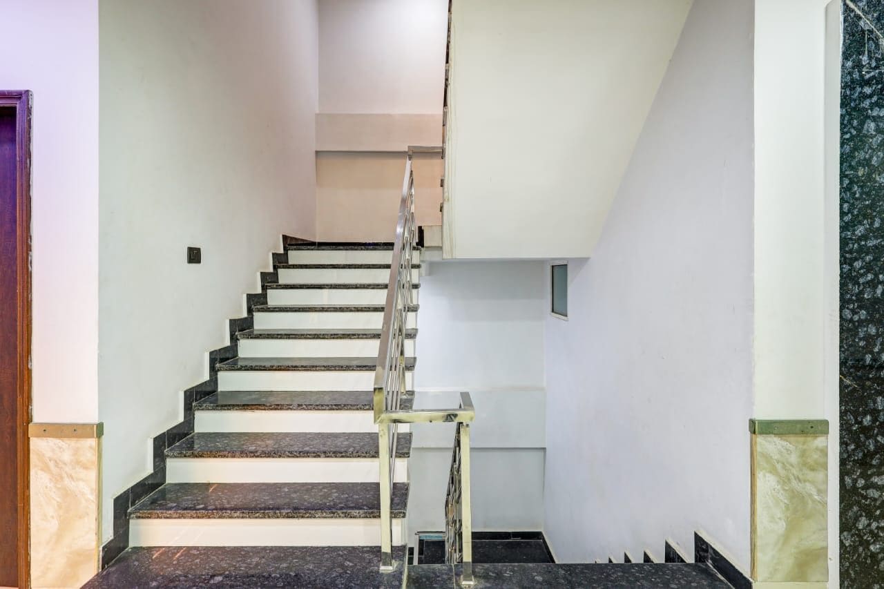 Una escalera con barandilla de cristal que sube a un piso superior.