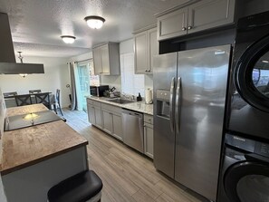 A modern kitchen with stainless steel appliances, a dining area with a table and chairs, and a view of the outdoors. - Fabulous 3-bedroom house with AC in charming Everett (Everett)