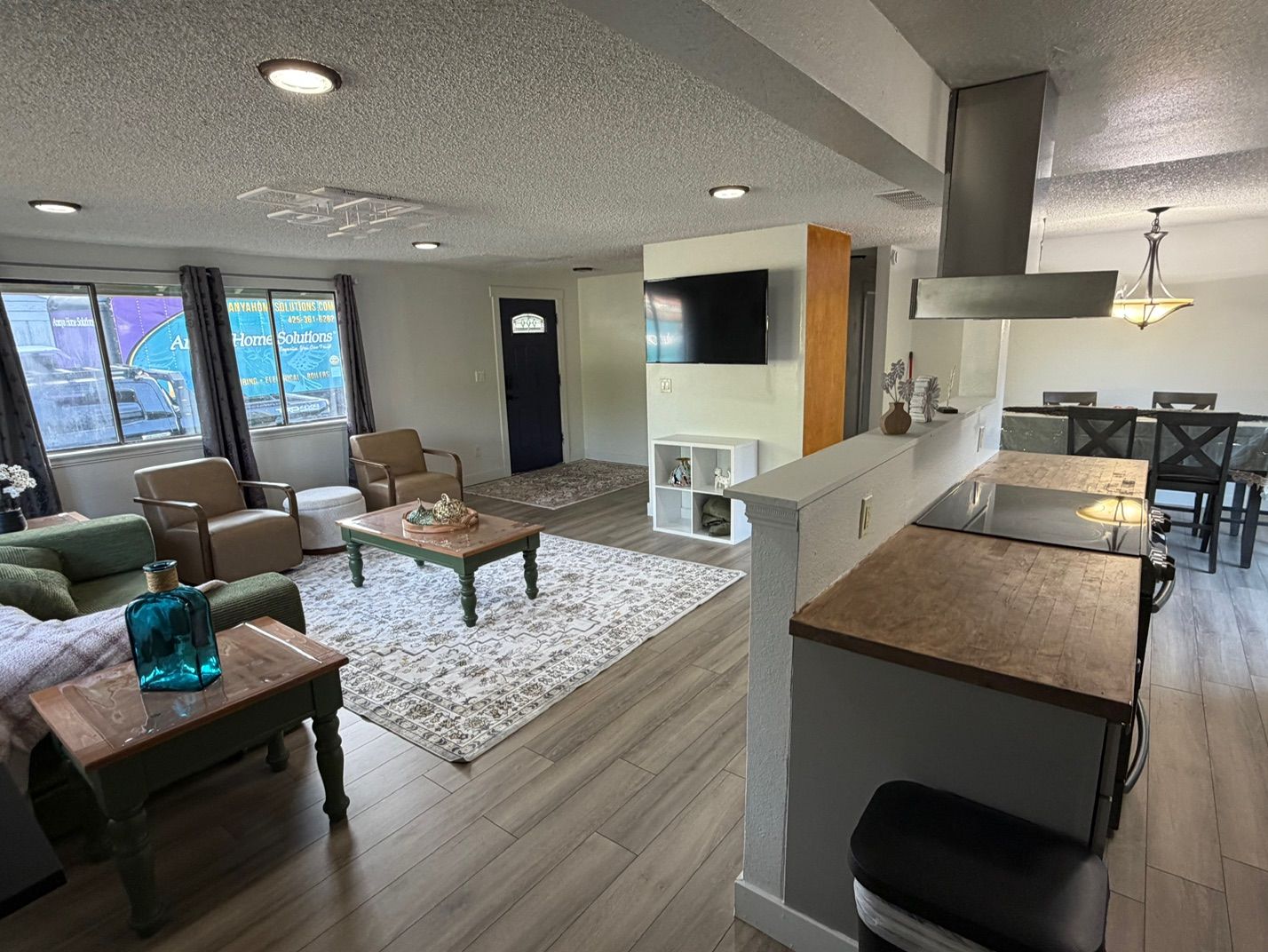 A modern living room with a sofa, coffee table, and a dining area with a table and chairs.