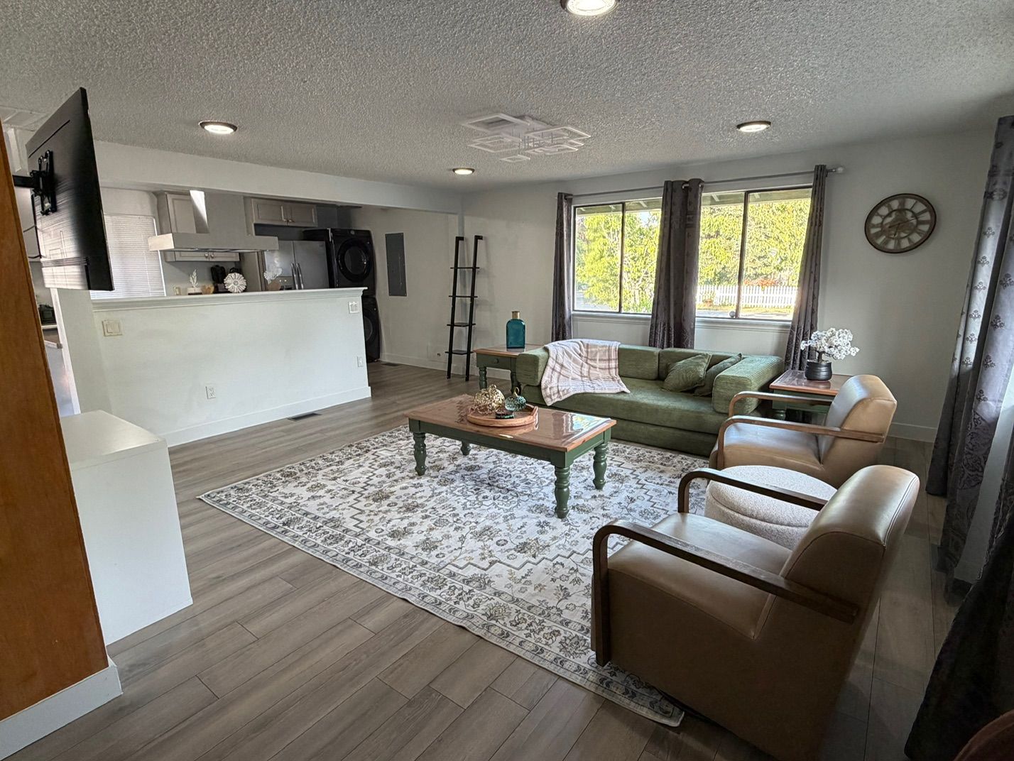 A modern living room with a sofa, coffee table, and a view of the kitchen.