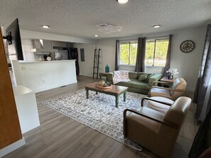 A modern living room with a sofa, coffee table, and a view of the kitchen. - Fabulous 3-bedroom house with AC in charming Everett (Everett)