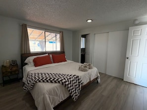 A bedroom with a bed, a window, a door, and a nightstand. - Fabulous 3-bedroom house with AC in charming Everett (Everett)