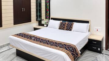 A bedroom with a large bed, a nightstand, a wardrobe, and a mirror.
