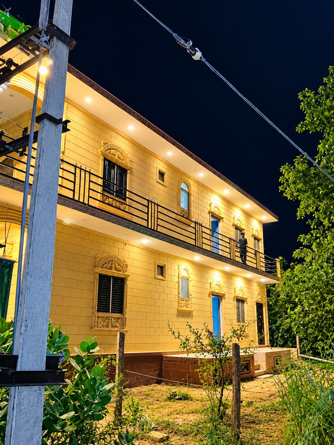 A multi-story building with balconies and a well-lit facade.