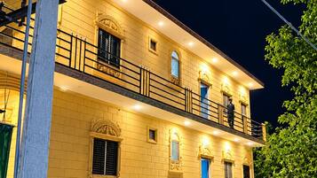 A multi-story building with balconies and a well-lit facade.