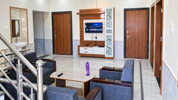 A hotel lobby with a reception desk, seating area, and a staircase.