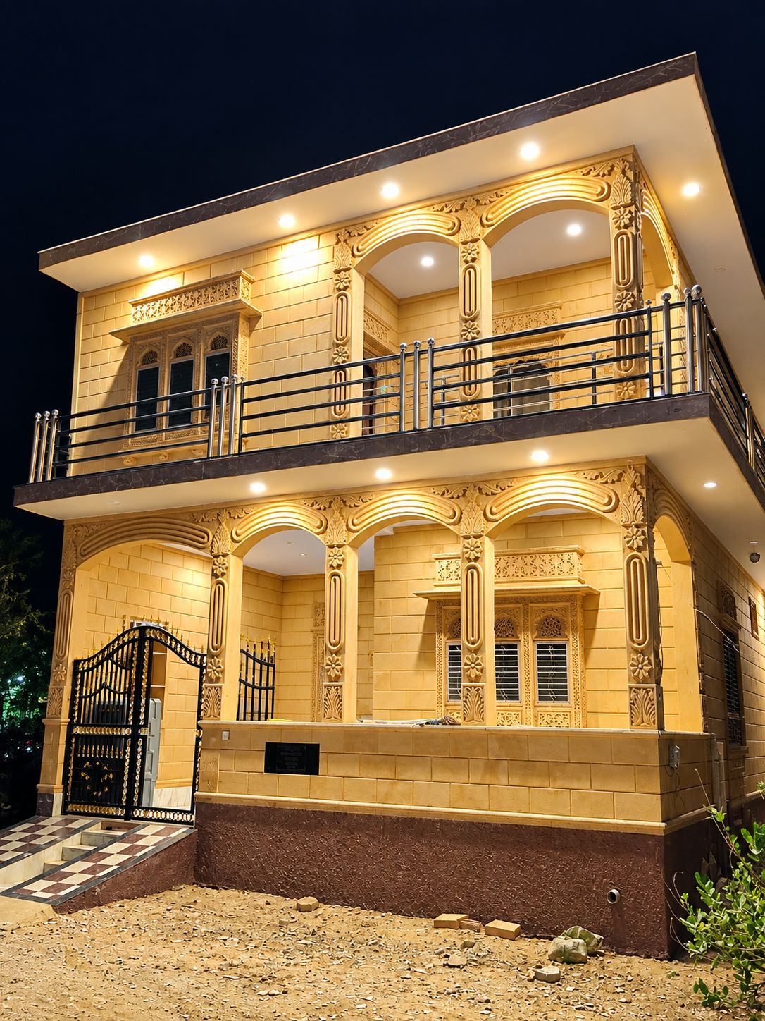 A two-story building with ornate architectural details, a balcony, and a gated entrance.