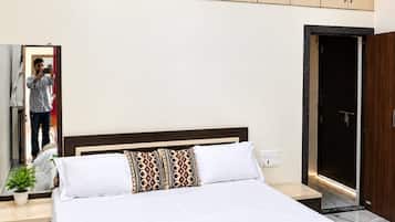 A bedroom with a bed, a nightstand, a mirror, and a wardrobe.