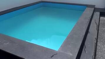Ein rechteckiger Swimmingpool mit dunkler Umrandung.