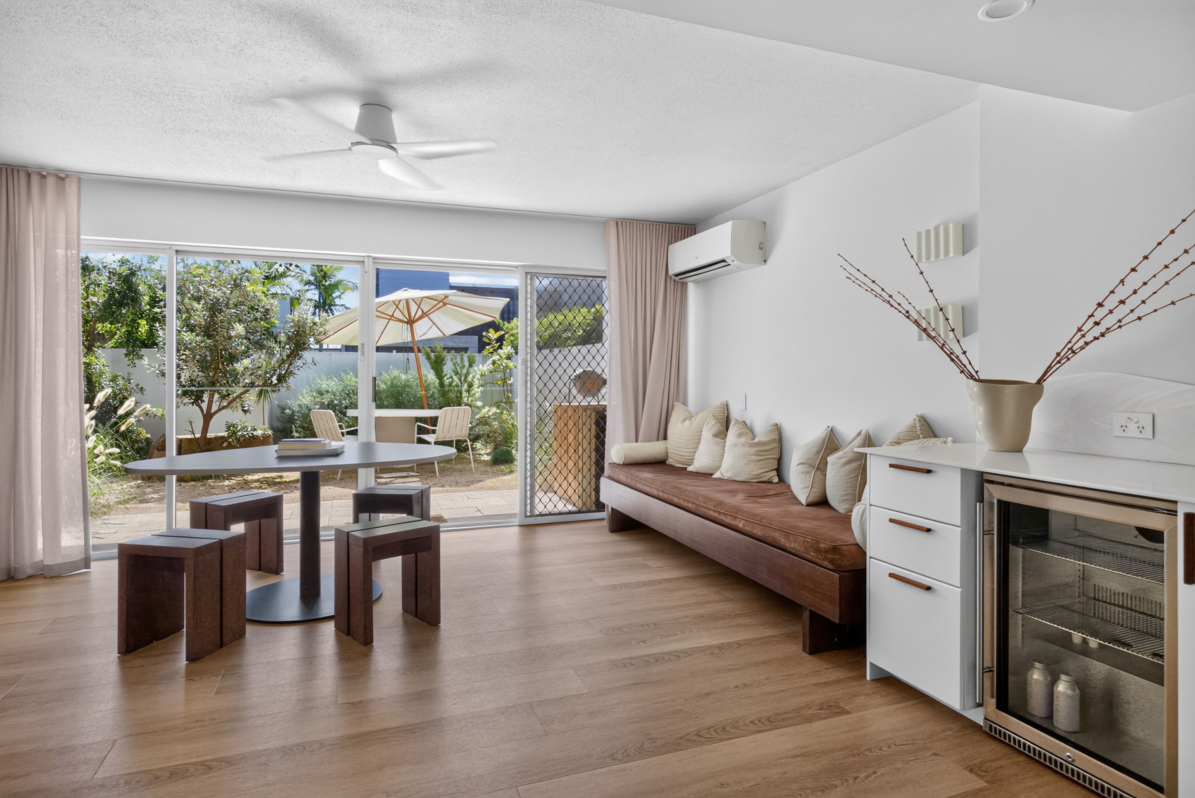A modern kitchen with a built-in oven and a dining area with a table and chairs.