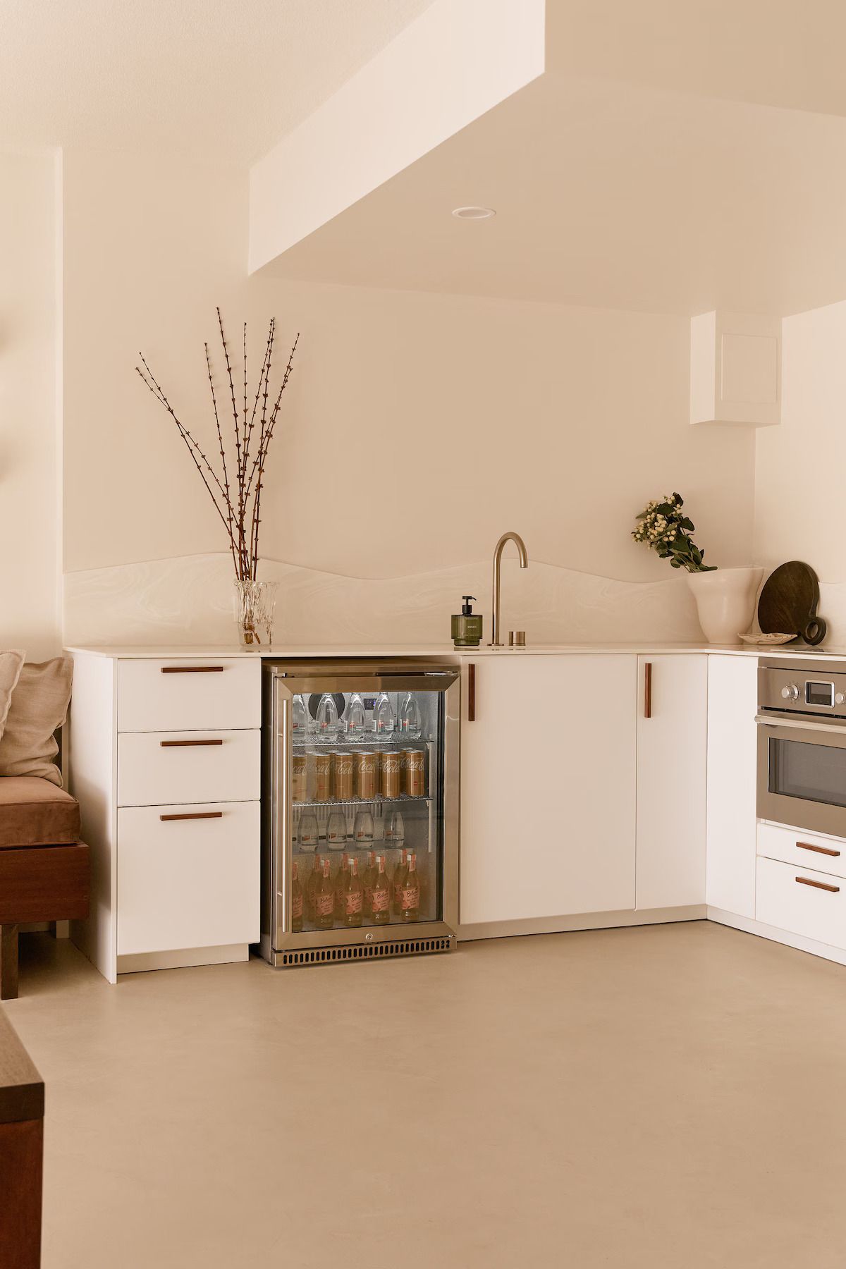 A modern kitchen with white cabinetry, a built-in refrigerator, and a stove.