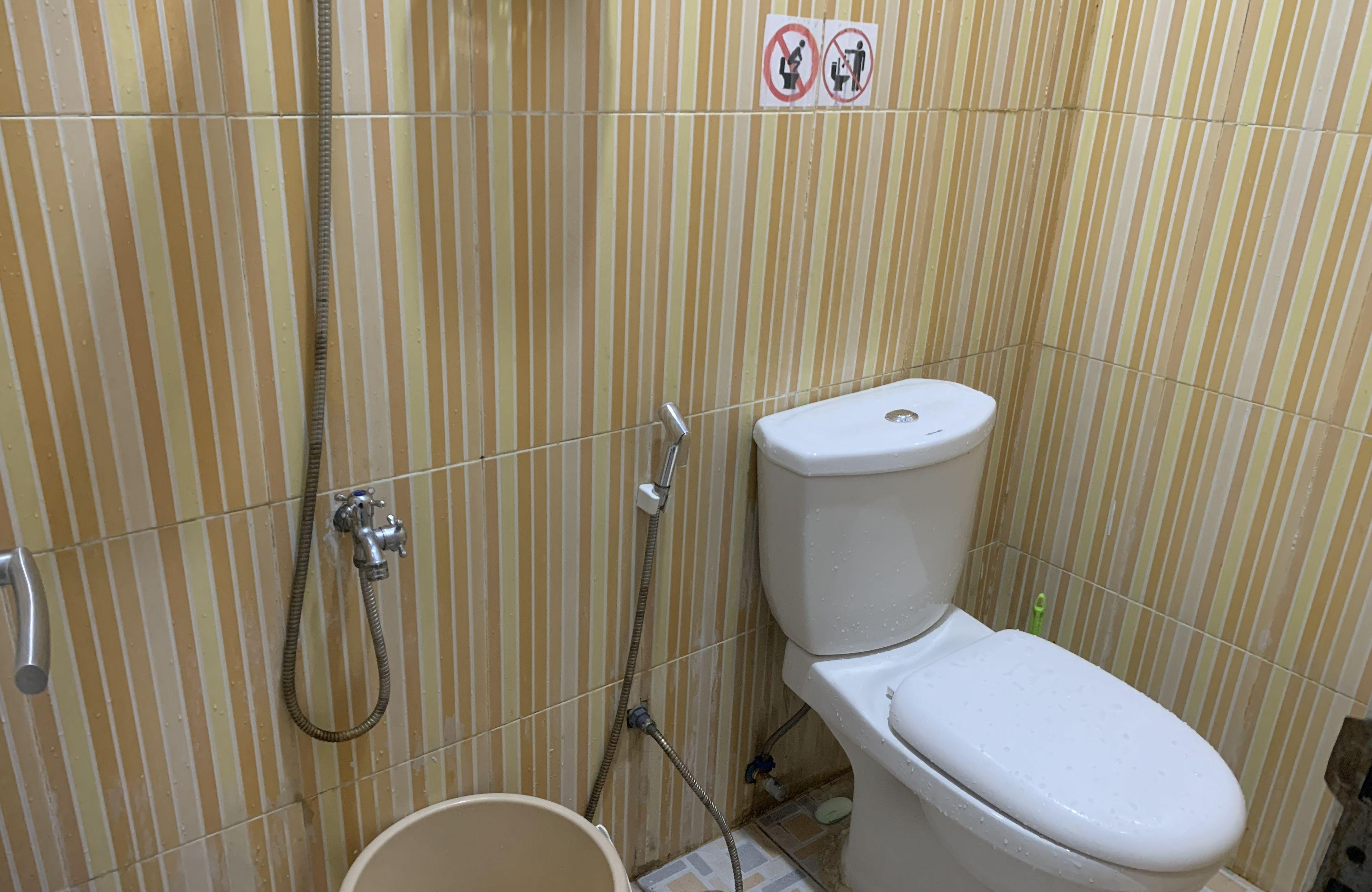 Kylpyhuone, jossa on wc, suihku ja ämpäri.