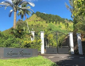 A gated entrance with a sign reading 'Legends Residences' and a palm tree in the background. - Moorea Villa with Hot Tub & Outdoor Bath – Walk to Pool, Tennis & Gym (Moorea-Maiao)