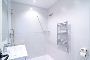 A modern bathroom with a glass-enclosed shower, a white sink, and a towel rack. - Villa in Nerja Near Burriana Beach (Nerja)