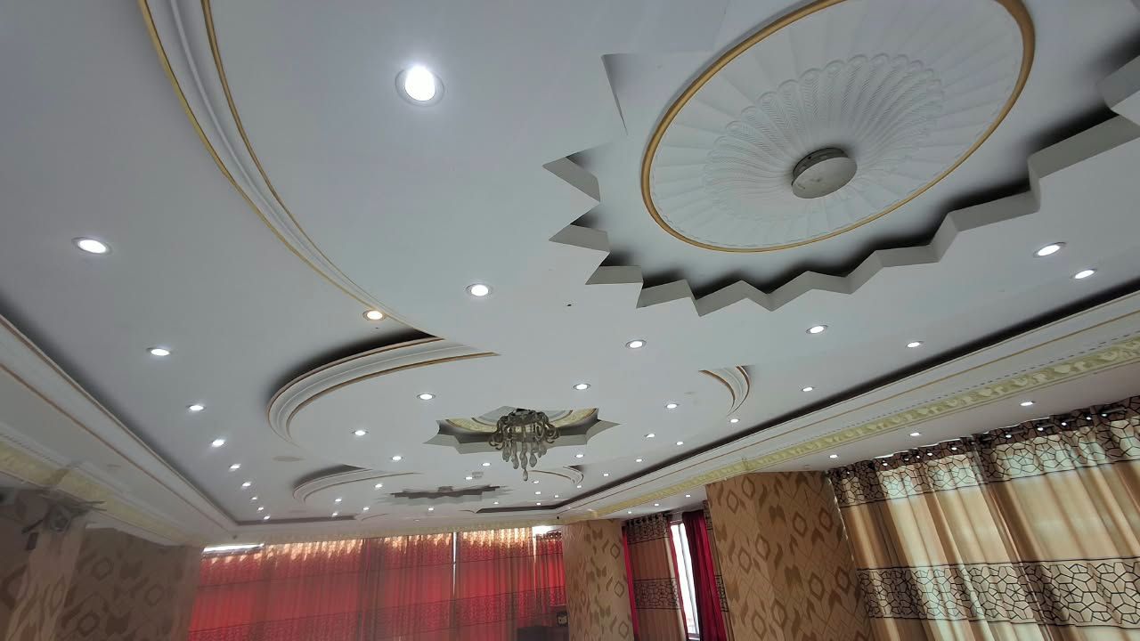 A ceiling with intricate patterns and recessed lighting.