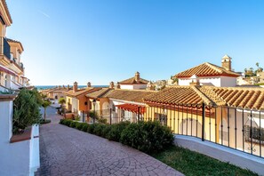 A residential street with terracotta-tiled roofs, a paved walkway, and a clear sky. - Apartment in Nerja Near Burriana Beach (Nerja)