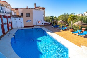 A swimming pool with a lifebuoy, a bench, and lounge chairs. - Apartment in Nerja Near Burriana Beach (Nerja)