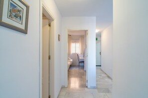 A hallway leading to a bathroom with a bed and a toilet. - Apartment in Nerja Near Burriana Beach (Nerja)