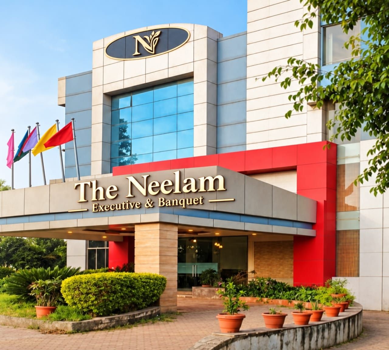 Ein Hotel mit einer modernen Fassade, einem auffälligen 'N'-Logo und der Bezeichnung 'The Neelam Executive & Banquet'.
