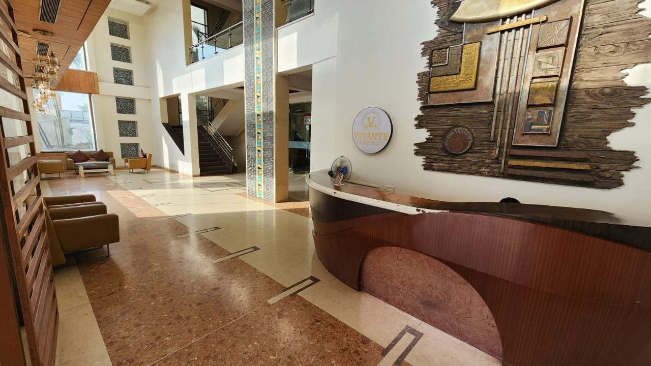 Un hall espacioso con mostrador de recepción, zona de estar y una escalera.