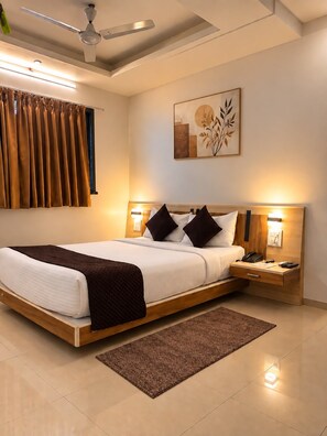 A modern bedroom with a bed, bedside lamps, a ceiling fan, and a wall-mounted artwork.