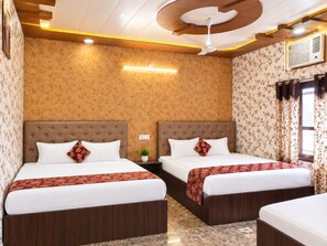 A hotel room with two beds, a ceiling fan, and a window with curtains. - Jindal Bed and Breakfast (Amritsar)