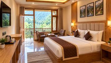 A modern hotel room with a large bed, a desk with a coffee maker, a chair, and a balcony with a scenic view.