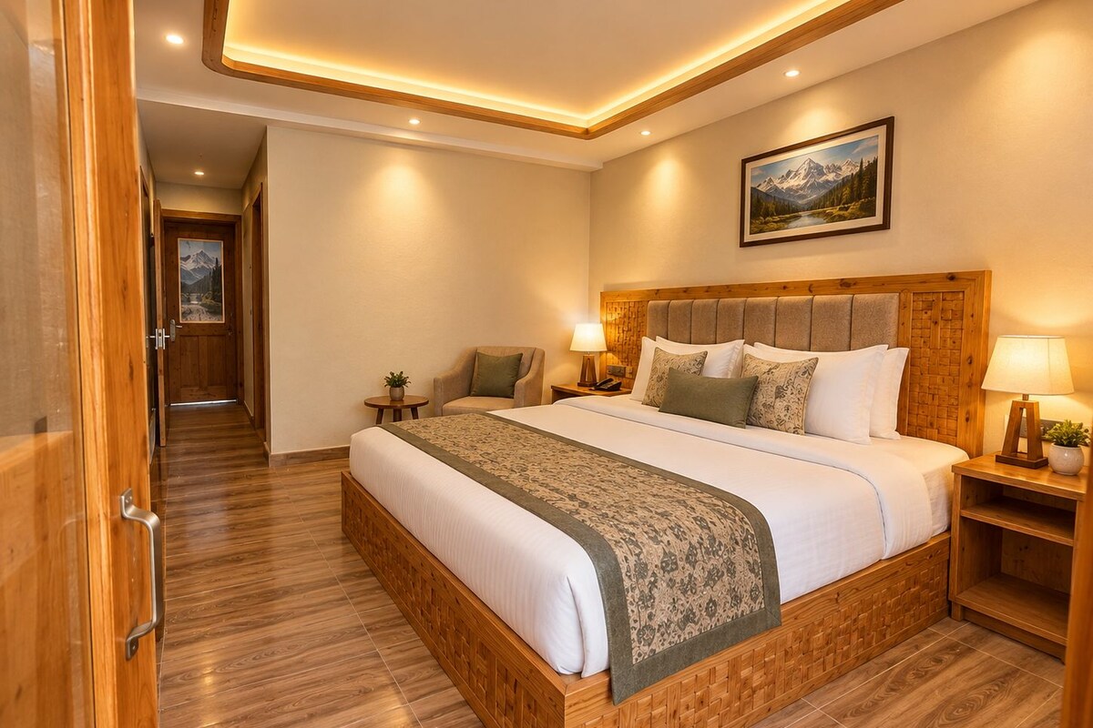 Una habitación de hotel con estructura de cama de madera, una cama grande, una mesita de noche con una lámpara, un cuadro colgado en la pared y suelo de madera.