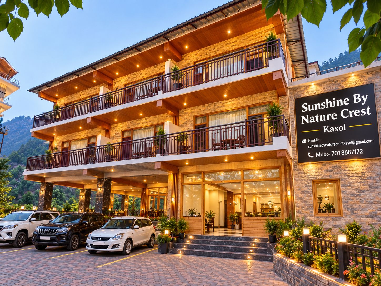 A multi-story hotel with a stone facade, balconies, and a sign advertising 'Sunshine By Nature Crest Kasol'.