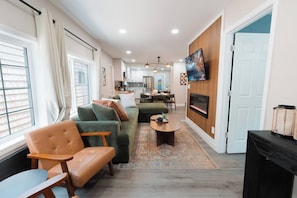 A modern living room with a sofa, chairs, a coffee table, and a fireplace. - 5 Min to Downtown | Hot Tub • Arcade • Sleeps 11 (Indianapolis)