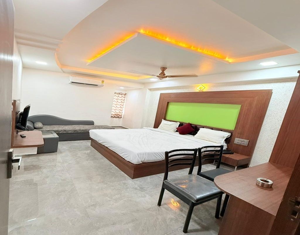 A modern bedroom with a bed, bedside tables, a desk, and a chair.