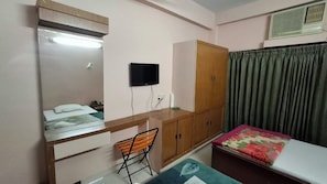 A bedroom with a bed, a desk, a chair, a wardrobe, and a television. - Hotel jalico Khulna (Khulna)