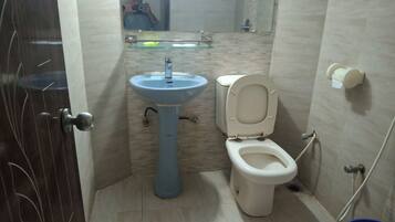 A bathroom with a sink, toilet, and a mirror.