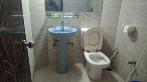 Une salle de bain avec un lavabo, des toilettes et un miroir.